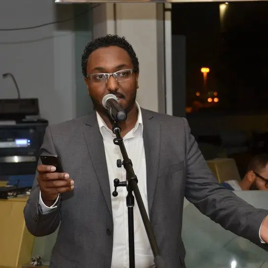 Host speaking on stage at a Lamatna event
