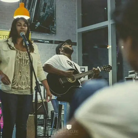Singer and guitarist performing at an open mic