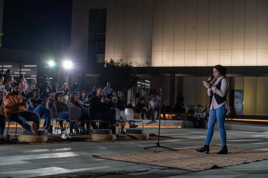 Performer facing a seated audience at night
