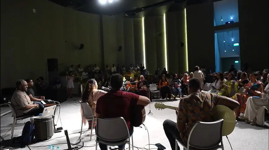 Audience seated outdoors in the evening