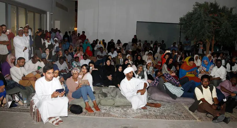 Audience seated on floor cushions